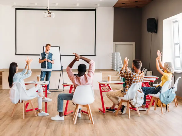 A group of college students taking part in a classroom presentation