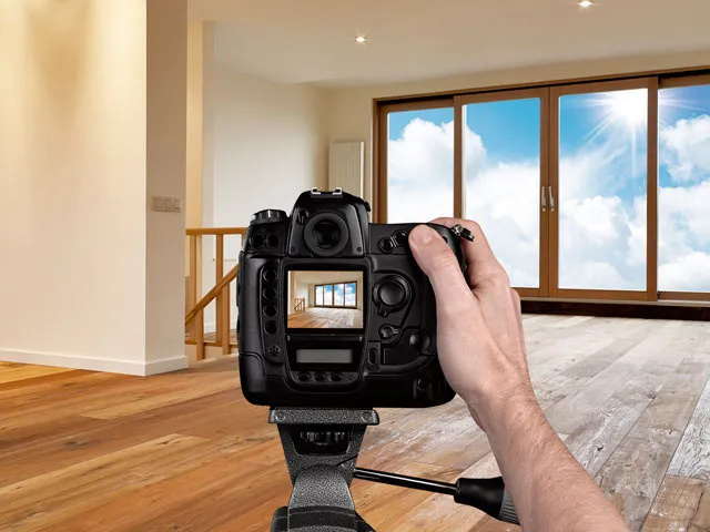 A photographer taking still shots of the inside of a clean home for sale