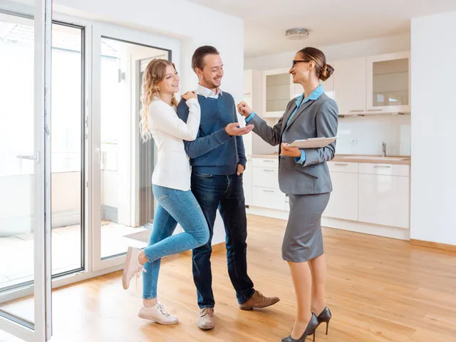 A Licensed Realtor handing the new homeowners their set of keys