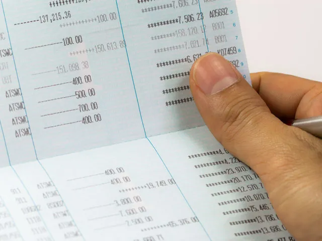A person reviewing their monthly bank statement